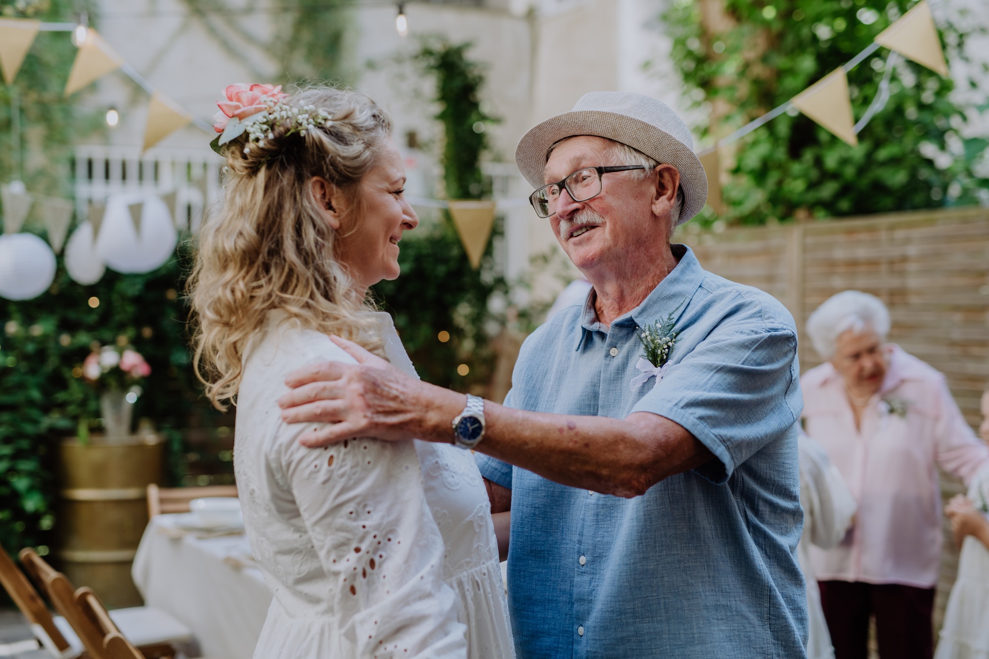Mature bride receiving congratulations at wedding reception outside in the backyard.