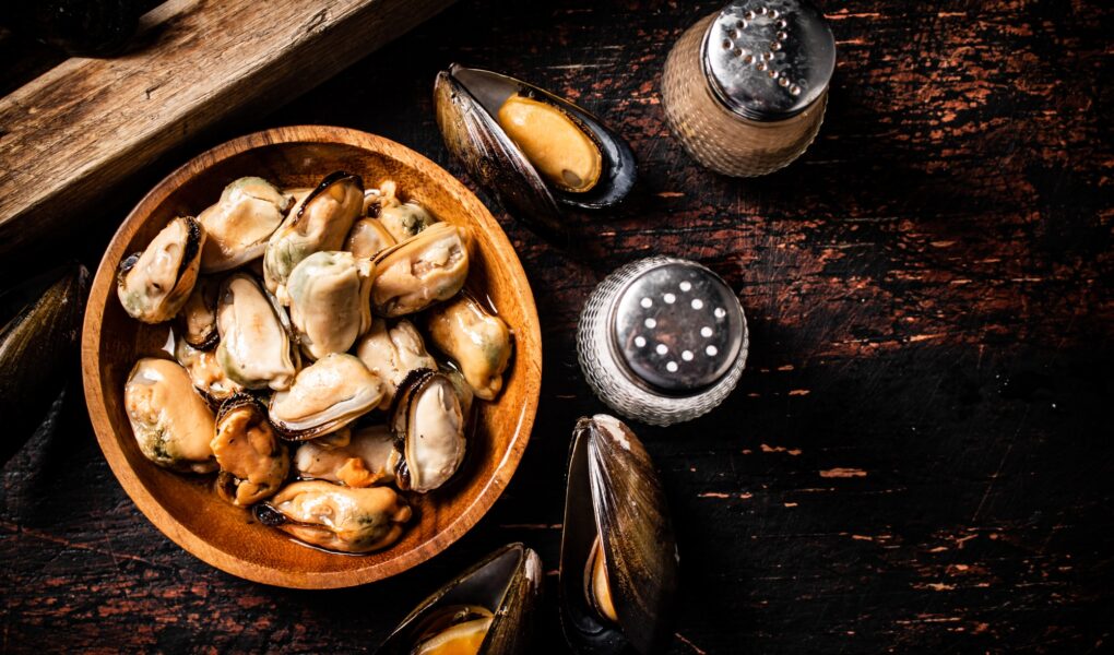 Pickled mussels in a wooden plate on the table.
