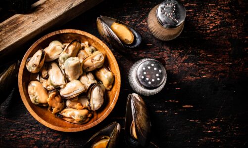 Pickled mussels in a wooden plate on the table.
